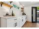Bright kitchen with white cabinets, black handles and trim, quartz counters and warm wood shelves at 4467 King St, Denver, CO 80211