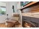 Cozy chair next to fireplace with stone surround in updated living room at 4467 King St, Denver, CO 80211