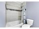 Updated bathroom with a tub shower, tile surround, and a toilet at 1818 S Quebec Way # 11-8, Denver, CO 80231