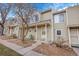 Tan colored townhome exterior with small front yard and walkway at 1818 S Quebec Way # 11-8, Denver, CO 80231