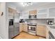 Modern kitchen with stainless steel appliances and wood cabinets at 1818 S Quebec Way # 11-8, Denver, CO 80231