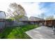 A spacious fenced backyard with a well-maintained lawn and a small patio area at 747 Mockingbird St, Brighton, CO 80601