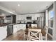 A modern kitchen featuring white cabinets, stainless steel appliances, and a cozy dining area at 747 Mockingbird St, Brighton, CO 80601