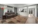 An open-concept living room with hardwood floors, gray walls, and a view of the modern kitchen at 747 Mockingbird St, Brighton, CO 80601