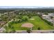 Aerial view of a park with two baseball fields with green grass, mature trees, and houses in the background at 1414 W Nevada Pl, Denver, CO 80223
