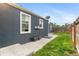 View of fenced backyard with grass and concrete walking path surrounding the house at 1414 W Nevada Pl, Denver, CO 80223