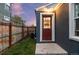 Exterior backyard featuring a privacy fence, newly painted wall, and red door, providing easy access at 1414 W Nevada Pl, Denver, CO 80223