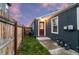 View of fenced backyard with grass, exterior back door, and meters on the outside of the house at 1414 W Nevada Pl, Denver, CO 80223