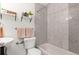 Updated bathroom showcases decorative wall tiles, new fixtures, and open shelving with decor at 1414 W Nevada Pl, Denver, CO 80223