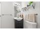 Bathroom featuring updated vanity with modern fixtures, decorative shelving, and neutral color palette at 1414 W Nevada Pl, Denver, CO 80223