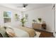 Bright, styled bedroom featuring hardwood floors, three windows, and natural decor at 1414 W Nevada Pl, Denver, CO 80223