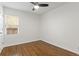 Bright bedroom features hardwood floors, a modern ceiling fan, and natural light from the window at 1414 W Nevada Pl, Denver, CO 80223