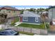 Charming home featuring a well-manicured lawn, a red front door, and a gray exterior at 1414 W Nevada Pl, Denver, CO 80223