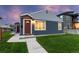 Charming home with a red door, lush lawn, and freshly painted exterior at dusk at 1414 W Nevada Pl, Denver, CO 80223