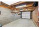 This is an unfinished garage with an electric garage door and exposed rafters at 1414 W Nevada Pl, Denver, CO 80223