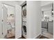 Hallway features a stacked washer/dryer, with a partial view of the kitchen and bathroom at 1414 W Nevada Pl, Denver, CO 80223