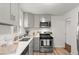 The kitchen features gray cabinets, a stainless steel gas range, and white quartz countertops at 1414 W Nevada Pl, Denver, CO 80223