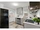 Cozy kitchen with stainless steel appliances, gas range, gray cabinets, and light-colored floors at 1414 W Nevada Pl, Denver, CO 80223