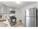 Well-lit kitchen with stainless steel appliances, gray cabinets, and modern countertops at 1414 W Nevada Pl, Denver, CO 80223