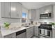 Well-lit kitchen featuring grey cabinets, stainless steel appliances, and white countertops at 1414 W Nevada Pl, Denver, CO 80223