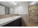 Basement bathroom with stone feature wall and modern vanity at 3131 S Leyden St, Denver, CO 80222