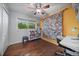 Bright bedroom with hardwood floors, a desk and chair, and a large wall tapestry at 3131 S Leyden St, Denver, CO 80222