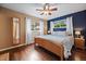 Main bedroom with a king-size bed, ceiling fan, and hardwood floors at 3131 S Leyden St, Denver, CO 80222