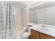 Bathroom featuring a shower-tub combination with a white tile surround and wood vanity at 7453 Singing Hills Dr, Boulder, CO 80301