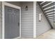 Attractive gray front door with matching siding, exterior light, and house number. Stairs to the side at 7453 Singing Hills Dr, Boulder, CO 80301