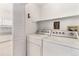 Bright laundry room with washer, dryer, louvered closet, and white walls at 7453 Singing Hills Dr, Boulder, CO 80301