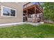 Lush backyard with a covered patio, perfect for outdoor relaxation and entertaining with view to the upper balcony at 10535 Laurelglen Cir, Highlands Ranch, CO 80130