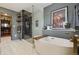 Spa-like bathroom featuring a freestanding tub, glass shower, and custom shelving at 10535 Laurelglen Cir, Highlands Ranch, CO 80130