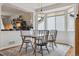 Well-lit dining room with hardwood floors, four chairs, and natural light from a window overlooking the side yard at 10535 Laurelglen Cir, Highlands Ranch, CO 80130