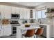 Well-lit kitchen with white cabinets, stainless steel appliances, a functional island, and subway tile backsplash at 10535 Laurelglen Cir, Highlands Ranch, CO 80130