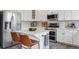 Bright kitchen featuring white cabinets, stainless steel appliances, a center island with seating, and modern fixtures at 10535 Laurelglen Cir, Highlands Ranch, CO 80130