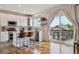Bright kitchen featuring white cabinets, stainless steel appliances, a center island with seating, and sliding glass door access at 10535 Laurelglen Cir, Highlands Ranch, CO 80130
