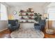 Bright living room featuring a decorative rug, two comfortable chairs, floating shelves, and hardwood floors at 10535 Laurelglen Cir, Highlands Ranch, CO 80130