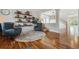 Open-concept living room with hardwood flooring, two stylish chairs, decor shelves, and natural light from the nearby windows at 10535 Laurelglen Cir, Highlands Ranch, CO 80130