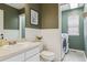 Charming powder room with stylish wainscoting, a sleek vanity, and convenient laundry area at 10535 Laurelglen Cir, Highlands Ranch, CO 80130