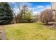 Spacious backyard with green grass and mature trees, perfect for outdoor activities and relaxation at 9743 Las Colinas Dr, Lone Tree, CO 80124