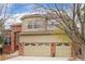Beautiful two-story home featuring a brick facade and a three-car garage with decorative doors at 9743 Las Colinas Dr, Lone Tree, CO 80124