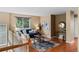 Cozy living room with hardwood floors, blue sofa, decorative rug, and bright natural light from large window at 9743 Las Colinas Dr, Lone Tree, CO 80124