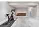 Large carpeted basement featuring modern lighting, a workout bike, and a stylish storage cabinet at 12919 W Burgundy Dr, Littleton, CO 80127