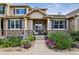 Charming home featuring a welcoming front porch with stone accents and beautiful landscaping at 12919 W Burgundy Dr, Littleton, CO 80127