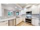 Modern kitchen featuring white cabinetry, stainless steel appliances, and granite countertops at 12919 W Burgundy Dr, Littleton, CO 80127