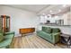 Open-concept space featuring a retro-style sofa and modern kitchen in the background at 12919 W Burgundy Dr, Littleton, CO 80127