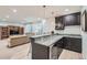 A bar with granite countertops, dark cabinetry, pendant lighting, and seating with a view of a living area at 15102 Prairie Pl, Broomfield, CO 80023