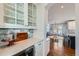 Dry bar area includes a wine fridge, white cabinets, and access to the dining room at 15102 Prairie Pl, Broomfield, CO 80023