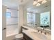 Well-lit bathroom featuring a tub-shower with white subway tiles, a modern vanity, and a view into the bedroom at 15102 Prairie Pl, Broomfield, CO 80023