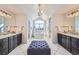 Bright bathroom featuring dual vanities, a soaking tub under a large window, and stylish tile flooring at 15102 Prairie Pl, Broomfield, CO 80023
